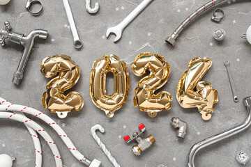 Composition with figure 2024 made of balloons, plumber's items and Christmas decor on grunge...