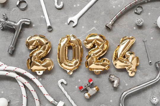 Composition with figure 2024 made of balloons, plumber's items and Christmas decor on grunge background