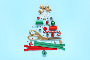Christmas tree made of sewing accessories and decorations on color background