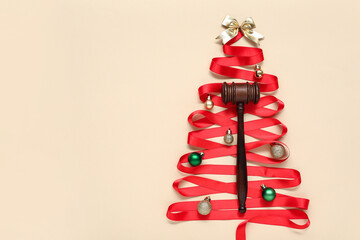 Christmas tree made of red ribbon, judge gavel and decorations on color background