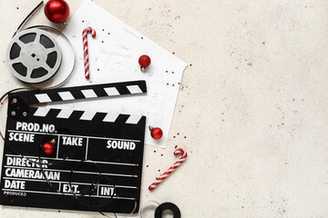 Composition with movie clapper, reel, storyboards and Christmas decorations on light background