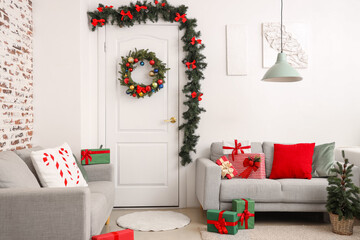 Interior of room with beautiful Christmas wreath and gifts