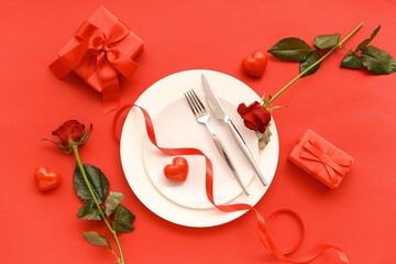 Beautiful table setting with red roses, gift boxes and hearts on color background. Valentine's Day celebration