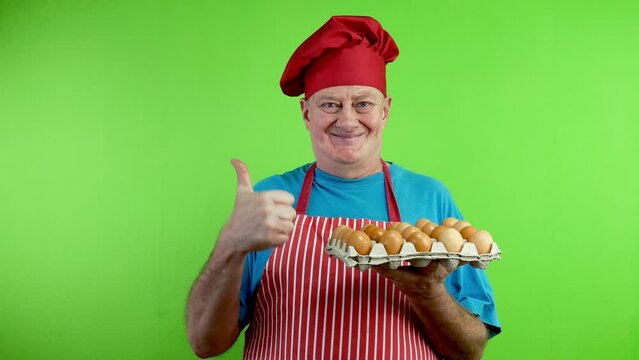 Senior chef show cartboard box with chicken eggs.
