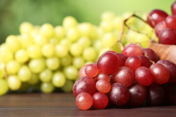 Different fresh ripe grapes on dark wooden table, closeup