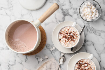 Aromatic hot chocolate with marshmallows and cocoa powder served on white marble table, flat lay
