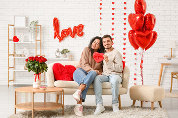 Young couple with gift for Valentine's day at home