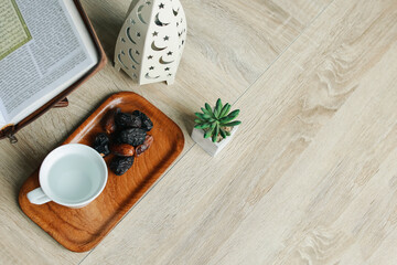 Top view of a cup mineral water and dates fruit on wooden table. Ramadan decoration background