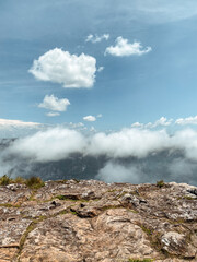 Fog and clouds in the peak of a green mountain with blue sky and good conditions