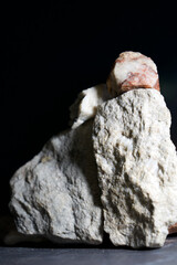 stacked unpolished quartz rocks, with black background, vertical