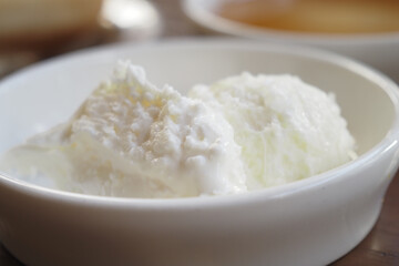butter cream and honey in a bowl on table .