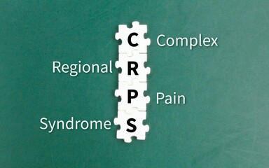 white puzzle with the letters CRPS or the word complex regional pain syndrome. disease or medical...