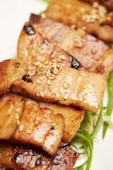 Grilled pork belly with green onions on a plate