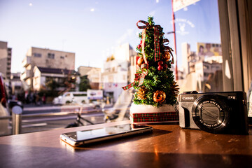 mini christmas tree on the table at a coffee shop - obrazy, fototapety, plakaty