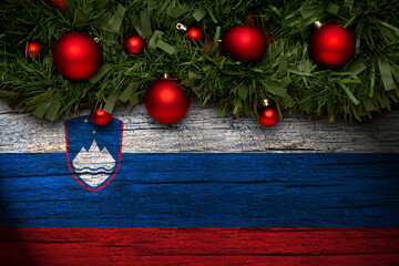 Christmas background made with garlands on a slovenia flag background. Christmas greeting from...