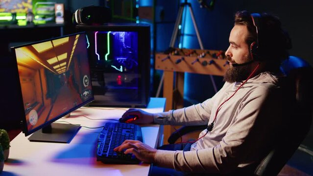 Man upset after losing while playing FPS videogame, using headphones mic to talk with friends. Gamer shutting down computer in anger after receiving game over screen, blaming online teammates