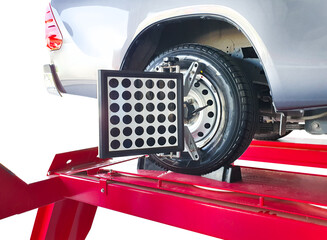Wheel alignment of car on lifting stand with a laser sensor during suspension angle adjustment in...