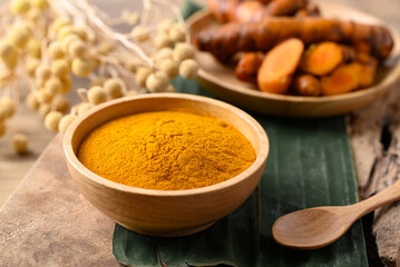 Turmeric powder and fresh turmeric in wooden bowl, Spice in Asian cuisine