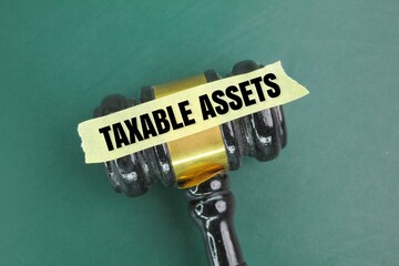 judge's gavel and a sticker with the word taxable asset. the concept of tax or asset tax - obrazy, fototapety, plakaty