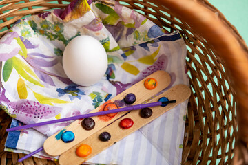 huevo cocido en blanco en canasta de mimbre y materiales de pintura para decorar huevo de pascua