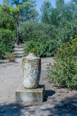 Fototapeta na wymiar Ancient stone urn on concrete plinths in garden part of the Agora ruins in Athens, Greece.