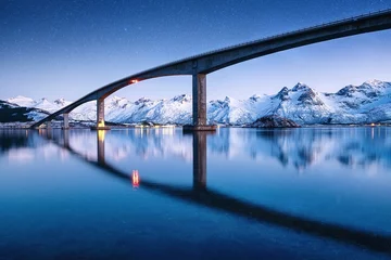 Abwaschbare Fototapete Nordeuropa Bridge, water and night sky with stars. Reflection on the water surface. Natural landscape in the Norway at the night time. Travel  - image