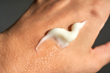 Fototapeta premium A smear of white moisturizer or sunscreen on a woman's hand.