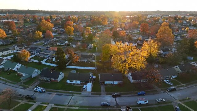 American neighborhoods in autumn. Yellow trees in the fall during sunset over houses.