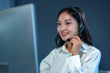 Young Asian call center woman working in a company. Attractive office worker sitting at a desk,...