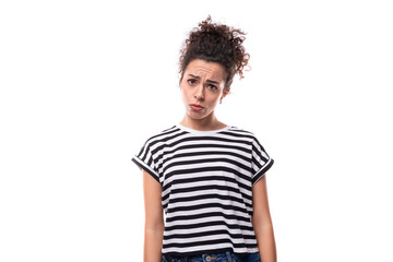 Obraz premium young curly brunette woman in a striped t-shirt on a white background with copy space