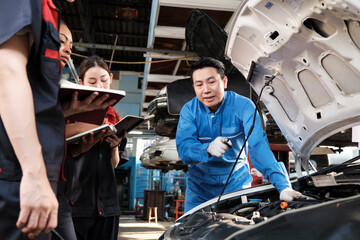 Asian male professional automotive engineer supervisor describes car engine maintenance and repair...