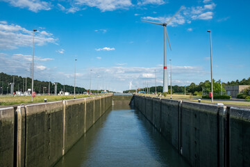 The image displays a spacious lock canal under a clear blue sky, a testament to modern maritime...