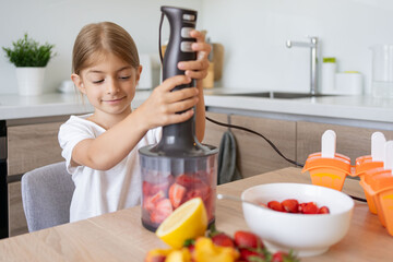 Child girl making ice cream at home, fruit ice lollipops