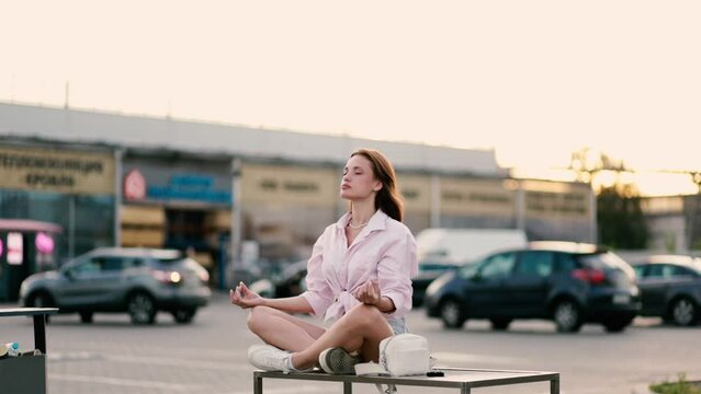 young woman relaxes and meditates in the city on a bench, the concept of existential crisis and professional burnout
