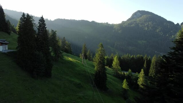 A power line and a steep rope way during sunset in the Alps in Lofer, Austria