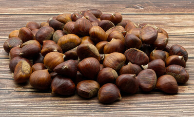 Chestnuts isolated on wooden table background.