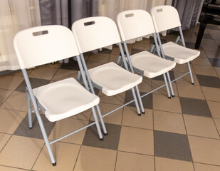 White chairs stand on tiles in the room