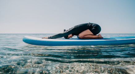 Woman sup yoga. Happy sporty woman practising yoga pilates on paddle sup surfboard. Female...