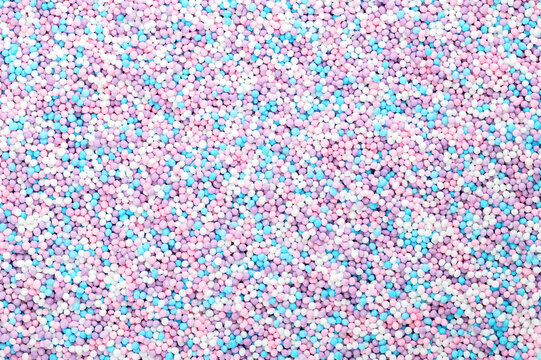 Colorful sprinkles made of tiny sugar balls. Mix of purple, blue, rose and white nonpareils. Decorative and edible Hundreds and Thousands made of sugar and starch, used as decoration and as topping.