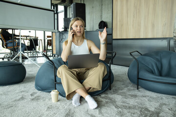 Obraz premium A young girl works on a laptop while sitting in a chair