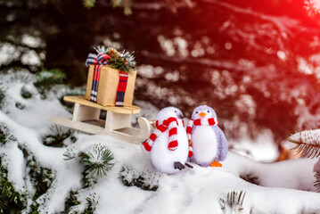 Christmas background-penguins carry a gift on a sled
