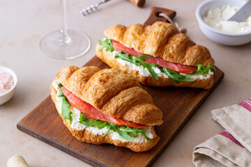 Croissants with salmon, white cheese and arugula. Breakfast.