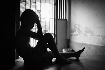 Child abuse concept, silhouette of  child confined in a dark room, prisoner or child abduction, child abuse human trafficking.