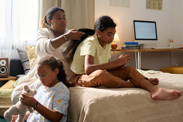 African American mother spending time with her daughters in the room