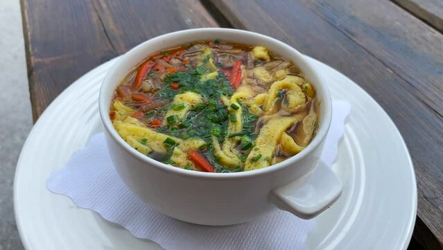Traditional Austrian Frittatensuppe in a bowl in Tyrol Austria, delicious hot comforting soup in Serfaus Fiss Ladis, 4K shot