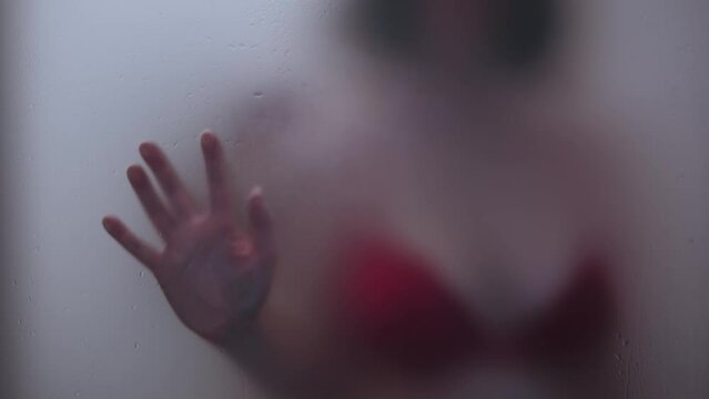 Couple having foreplay in the bathroom with the glass covered in steam
