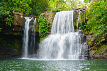 Fototapeta na wymiar Klong Chao waterfall serenely cascades and green water below in Koh Kood island, Thailand.