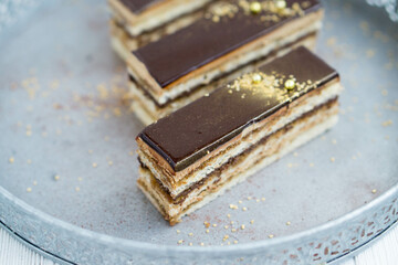Classic french pastry opera layered cake with almond sponge soaked in coffee syrup, buttercream ...