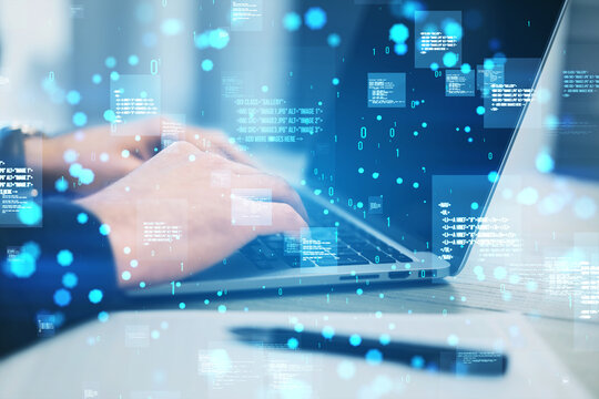 Close up of hands using laptop keyboard with creative binary coding hologram on blurry background. Software programming code. Double exposure.