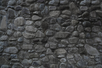 natural round stone wall background Rock and rounded stone wall texture with Old brick stone fence backdrop. front view.